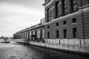 grayscale photo of a concrete building near the lake